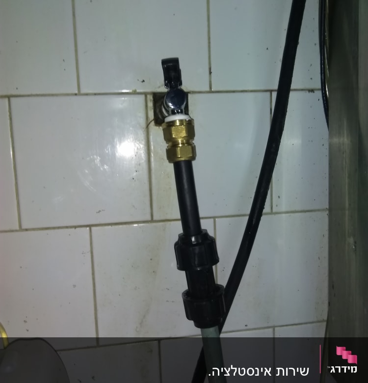 ברז פלסטיק מחובר לצינור על קיר אריחים